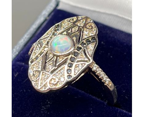 A Silver Art Deco style ring set with sapphires, CZ's and central opal. [Ring size O] 