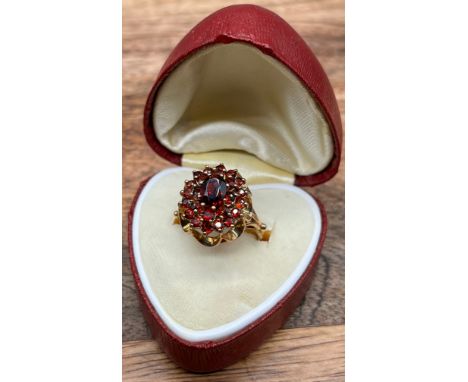 A Ladies 9ct gold ring set with a cluster of garnets. [4.60grams] [Ring size M] 