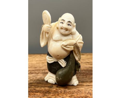 A Japanese Meiji period ivory carved netsuke of a laughing buddha holding a rat. [7cm in height] 