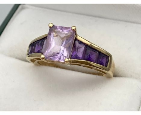 A Ladies 9ct yellow gold ring set with purple cut stones. [Ring size N] [3.02Grams] 