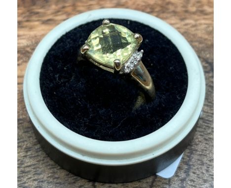 A Ladies 9ct yellow gold ring set with a large pale yellow stone off set by diamonds to each shoulder. [Ring size O] [3.06Gra