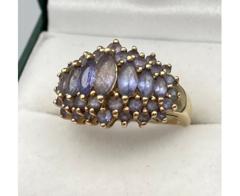 A Ladies 9ct yellow gold ring set with pale purple stones. [Ring size M] [4.66Grams] 