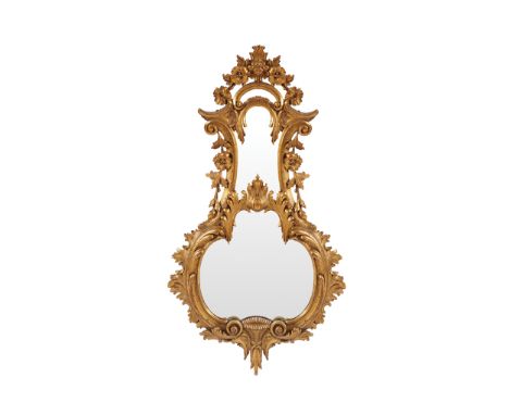 LATE EIGHTEENTH-CENTURY CHIPPENDALE CARVED GILTWOOD MIRRORwithin a stylized banjo shaped frame, below a hat and floral carved