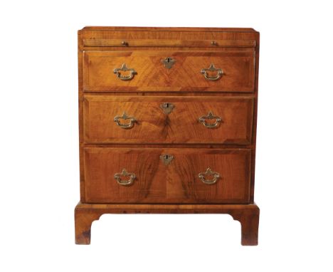 ANTIQUE WALNUT AND HERRING BONE INLAID CHESTof three drawers below a brushing slide, furnished with brass handles, raised on 