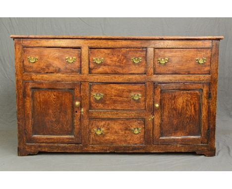 A GEORGE III AND LATER ELM AND OAK DRESSER, three short drawers above two cupboards and two further short drawers with later 