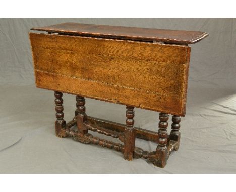 AN EARLY 18TH CENTURY OAK RECTANGULAR SINGLE DROP GATE LEG TABLE, moulded edge, on six bobbin and cotton reel turned legs and
