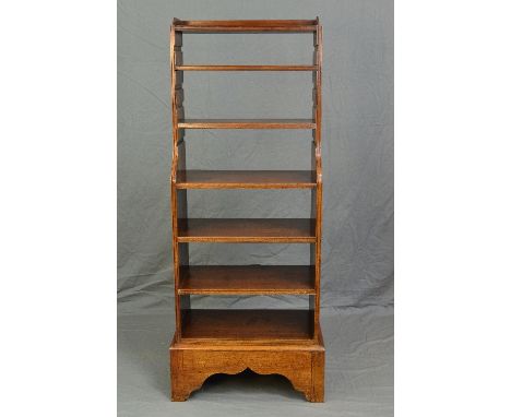 A 19TH CENTURY MAHOGANY WATERFALL BOOKCASE, with four adjustable sliding shelves and one fixed shelf, on a shaped plinth base