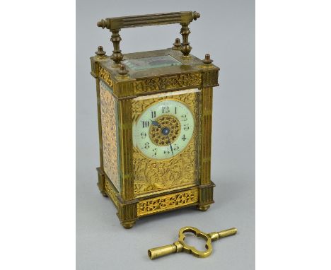 A LATE 19TH CENTURY GILT BRASS CARRIAGE CLOCK, the handle and four columns of square fluted design, five bevelled glass panel
