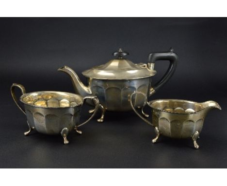 AN ELIZABETH II SILVER THREE PIECE TEA SERVICE, oval panelled form, on cabriole legs with paw feet, teapot with ebonised fitm