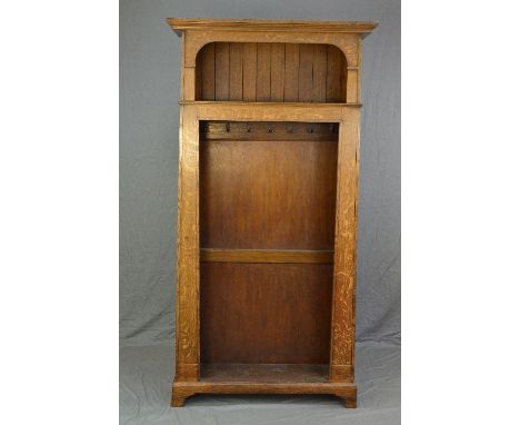 AN ARTS & CRAFTS OAK HALLSTAND, of pylon form, moulded cornice above a panelled back shelf, fitted with seven hooks below and