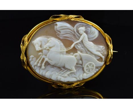 A LARGE OVAL SHELL CAMEO BROOCH, depicting a classical chariot scene, enclosed within a plain mount with engraved crossover s