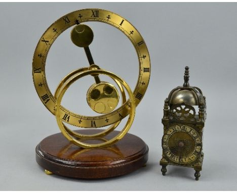 A MODERN BRASS MANTEL CLOCK WITH MYSTERY COUNTER BALANCE MOVEMENT, circular open form, Roman numerals, the reverse of the pen