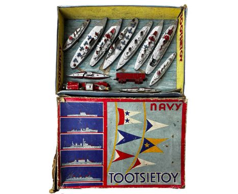 A collection of die-cast TootsieToys battle ships, fire engine and wagon, held within an original box