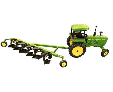 An ERTL 1:32 scale John Deere  4040 tractor with plough