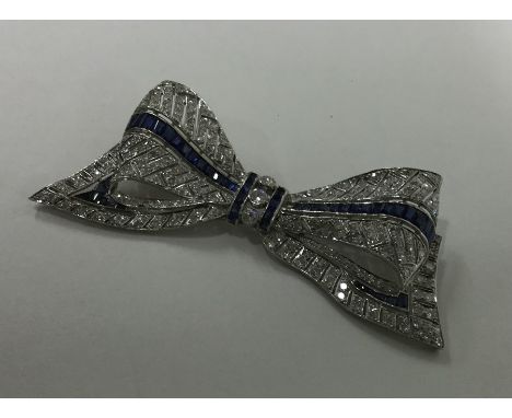 A large diamond brooch in the form of a bow with pierced decoration. Approx. 25 grams. Est. £1200 - £1500.