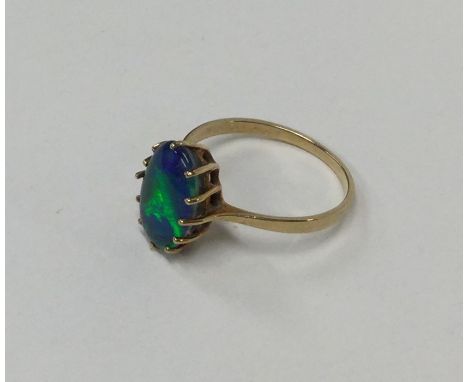 A large oval black opal single stone ring in claw mount. Approx. 2.1 grams. Est. £250 - £300.