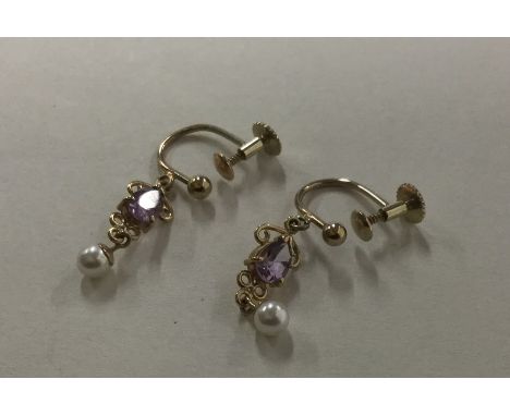 A pair of amethyst and pearl drop earrings set in 9 carat. Approx. 5.3 grams. Est. £40 - £60.