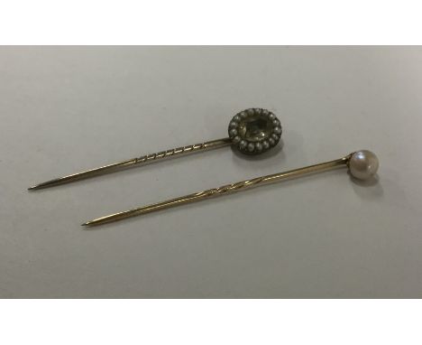 An Antique pearl mounted stick pin together with a gold and pearl stick pin. Approx. 3.1 grams. Est. £30 - £40.