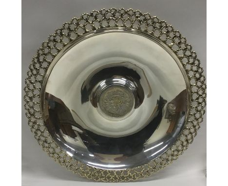 STUART DEVLIN: A large circular silver commemorative charger with silver gilt pierced modernistic border. Approx. 820 grams. 