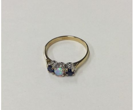 A sapphire and opal three stone ring in claw mount. Approx. 2.2 grams. Est. £30 - £40.