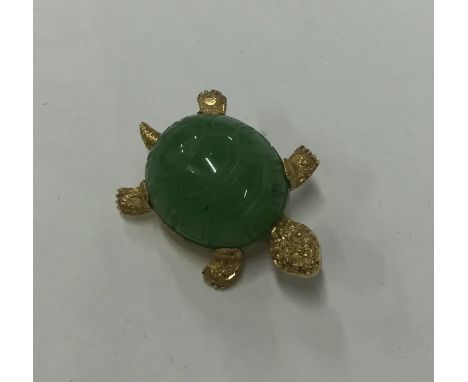 A carved jade brooch in the form of a tortoise in outstretched position set in 18 carat gold. Approx. 7.4 grams. Est. £450 - 