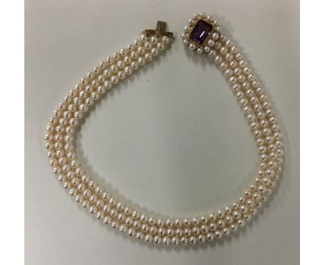 A cased gold mounted and pearl three row choker with concealed clasp. Approx. 83 grams. Est. £250 - £350.