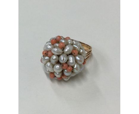 A coral and pearl ring in gold mount. Approx. 9.2 grams. Est. £50 - £80.