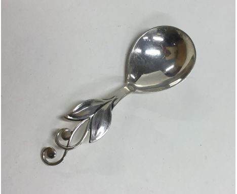 A stylish silver caddy spoon with floral decoration. Approx. 17 grams. Est. £20 - £30.