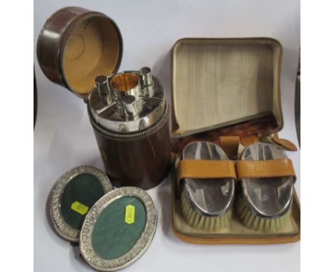 A cased pair of silver backed brushes, together with silver mounted comb, a cased German silver plated spirit flask set, in l