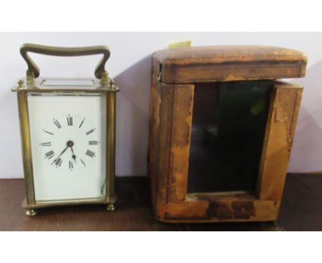 A brass carriage clock, with leather covered travel case
