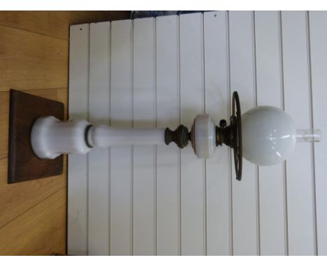 An opaline glass oil lamp with brass mounts, on oak base, 98cm tall