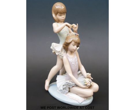 A Lladro figurine of two ballerinas putting flowers in their hair