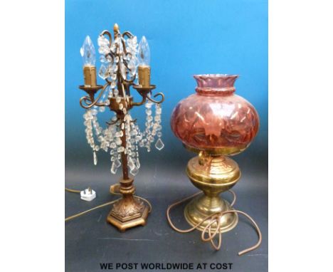 An oil lamp style table lamp with cranberry type glass shade and one other with crystal effect beaded shade