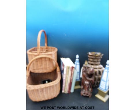 Two wicker baskets together with a large decanter shaped vase, two blue and white ceramic obelisks on brass bases, a carved w