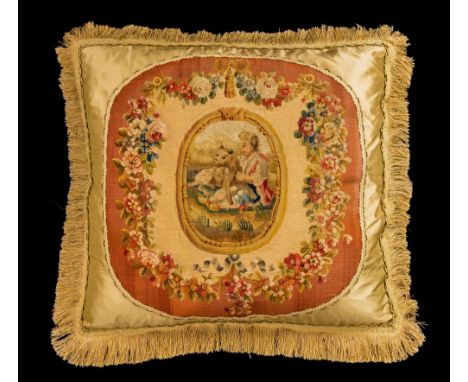 A pair of late 18th century Gobelin tapestry faced silk cushions, decorated with a figure and dog to the central reserve, wit