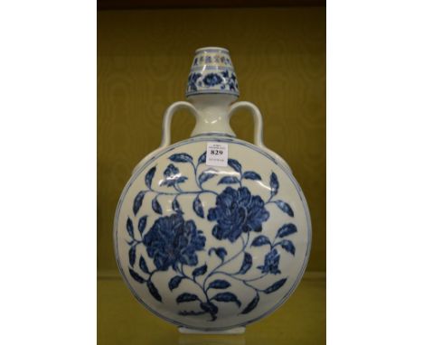 A Chinese blue and white moon flask painted with flowers.