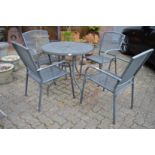 A grey painted aluminium circular patio table and four armchairs.