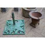 A cast iron parasol base and another item.