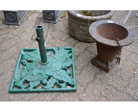A cast iron parasol base and another item.