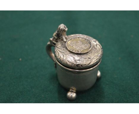 A small silver model of a peg tankard inset with a coin (29).