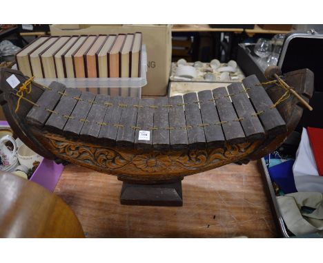 An unusual carved wood boat shaped xylophone.