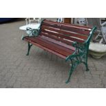 A new garden bench with green painted cast metal ends and hardwood slats.