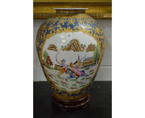A large Chinese pottery vase decorated with hunting scenes on a hardwood stand.