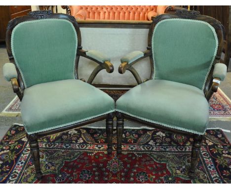 Pair of late Victorian rosewood open arm elbow chairs having carved moulded shaped backs with padded and shaped arms, standin