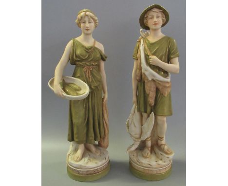 A pair of Royal Dux Art Nouveau porcelain figurines of a hunter and fish girl, shape no's 2122 and 2128, both with pink trian