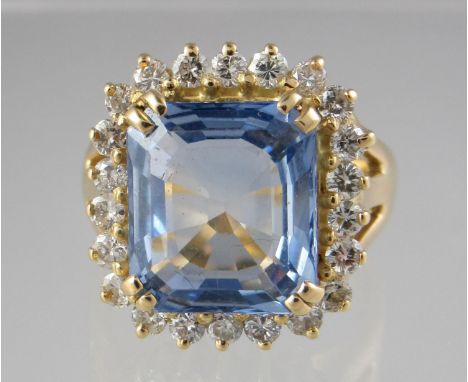 18ct gold sapphire and diamond ring. The step cut sapphire approx 11x10mm surrounded by diamonds. Ring size N&1/2. Approx wei