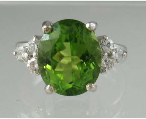 Oval peridot and diamond ring set in 9ct white gold.  Ring size M.  Approx weight 5.8 grams.(B.P. 21% + VAT) 