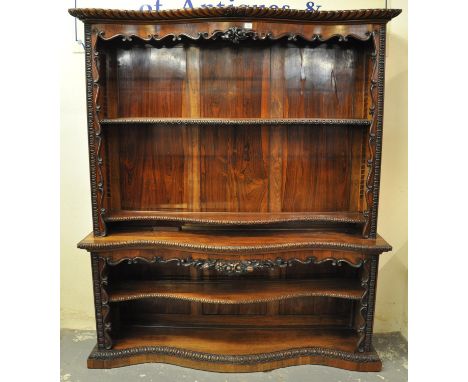 Victorian rosewood serpentine two stage open bookcase with carved and moulded flower heads and other decoration with adjustab
