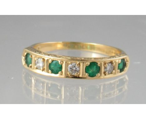 Emerald and diamond half eternity style ring of four emeralds and three diamonds set in yellow metal (tests as 18ct).  Ring s