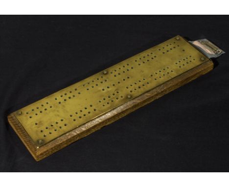 A brass and wood cribbage board